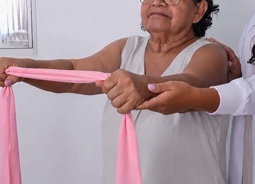 Paciente idosa realizando exercícios com faixa elástica